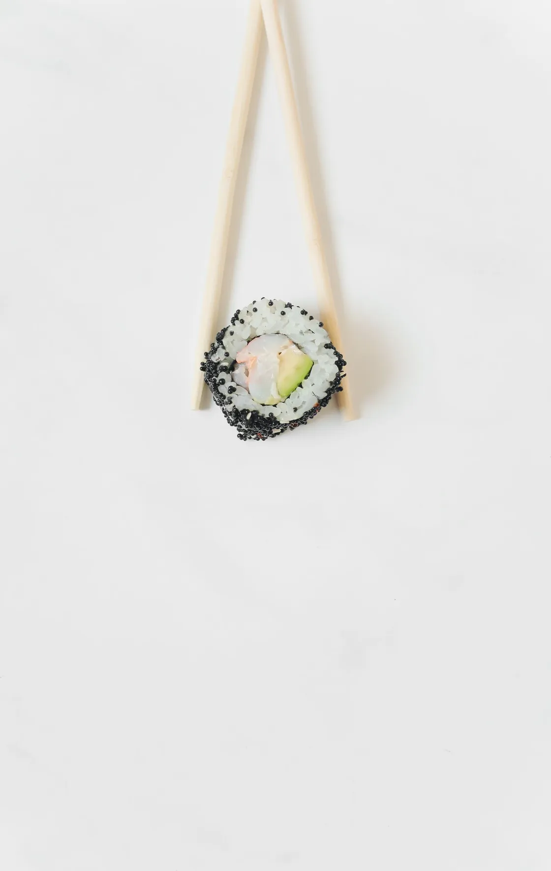 Roll uramaki de tobiko negro entre dos palillos